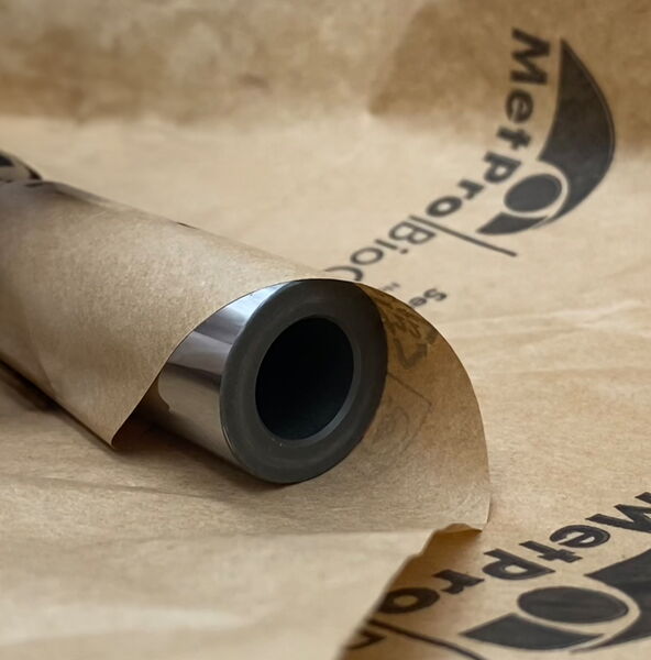 Ein Metallzylinder wird für den Schutz vor Korrosionsschutz in BioCor® Glattpapier eingewickelt.
